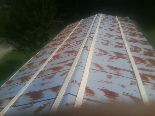 Rusted metal roof panels with new wood purlins before replacement — Storm Damage Roof Repair in Ellenwood by Roofing Brothers