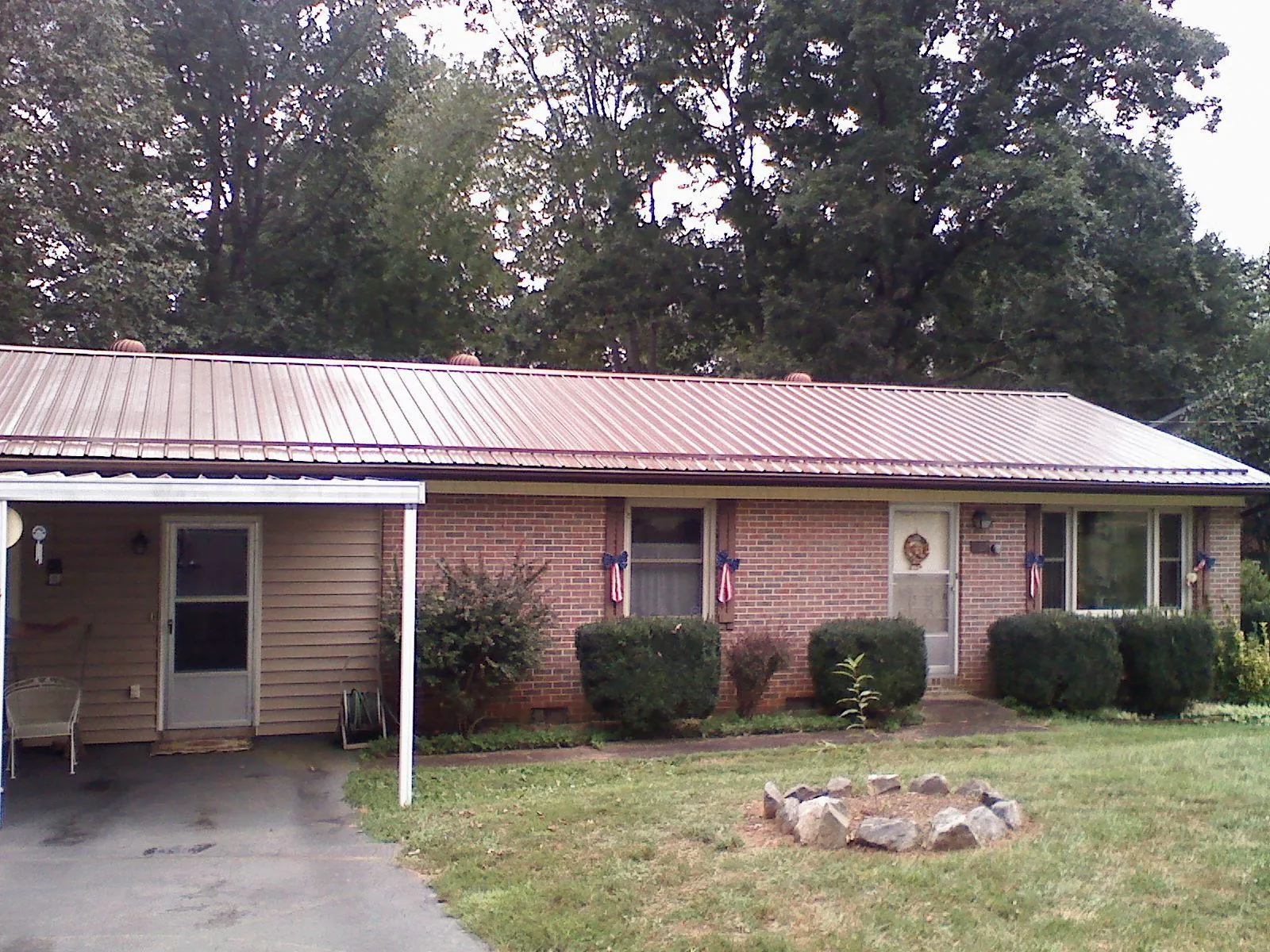 Bronze metal roof and carport on a brick ranch home — Roof Repair work by our crew in Ellenwood